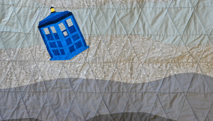 Photo of a TARDIS applique on a wavy quilt